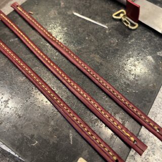 両側を手縫いし終えた三本の革製吊り下げベルト